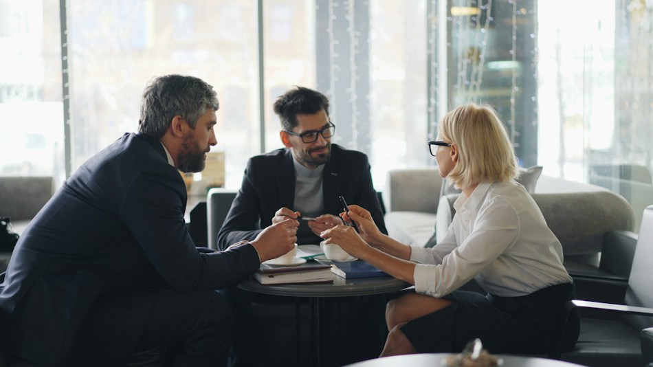 Illustrative consultation with three business professionals around a table