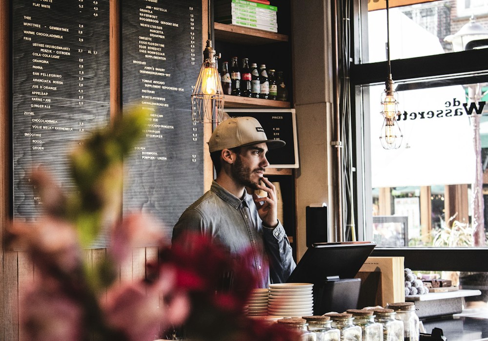 Illustrative café scene with a worker behind the service counter and menu boards
