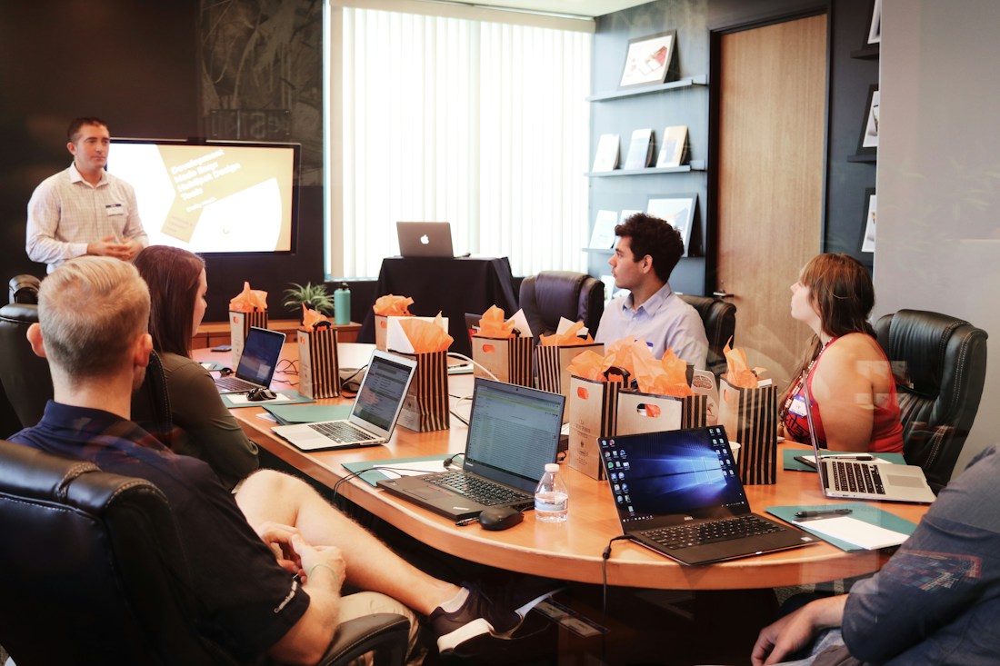 Illustrative business team discussing plans around a conference table