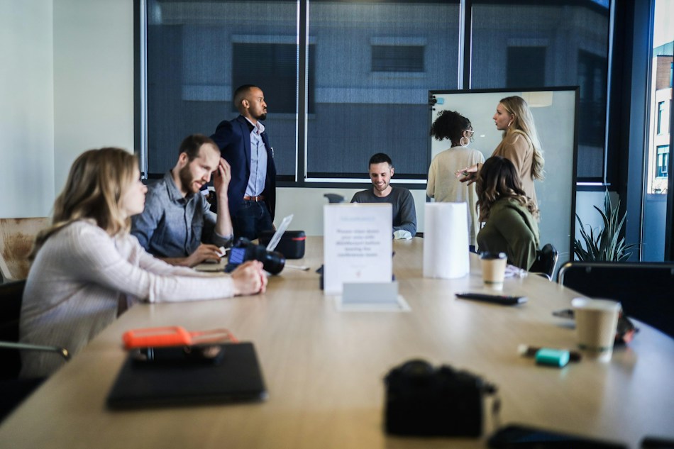 Illustrative business team discussing a project around an office table